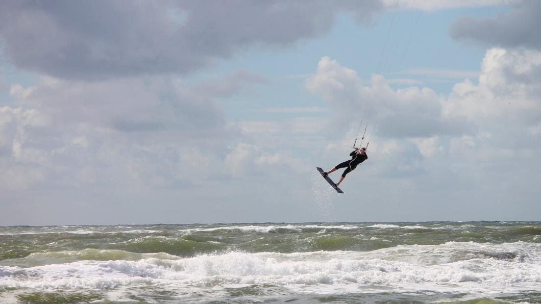 Kitesurfer springt boven woelige zee