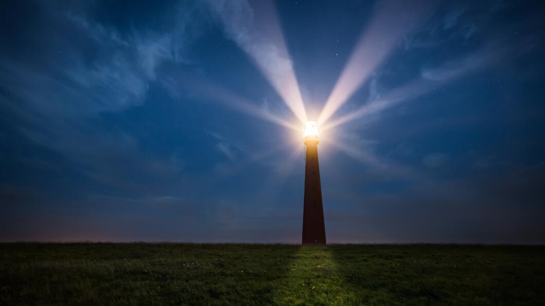 een vuurtoren met lichtbundels in de nacht