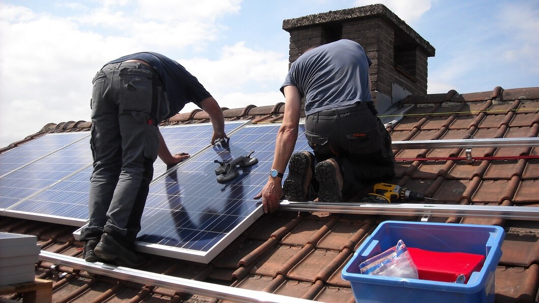 mannen bevestigen zonnepaneel op dak